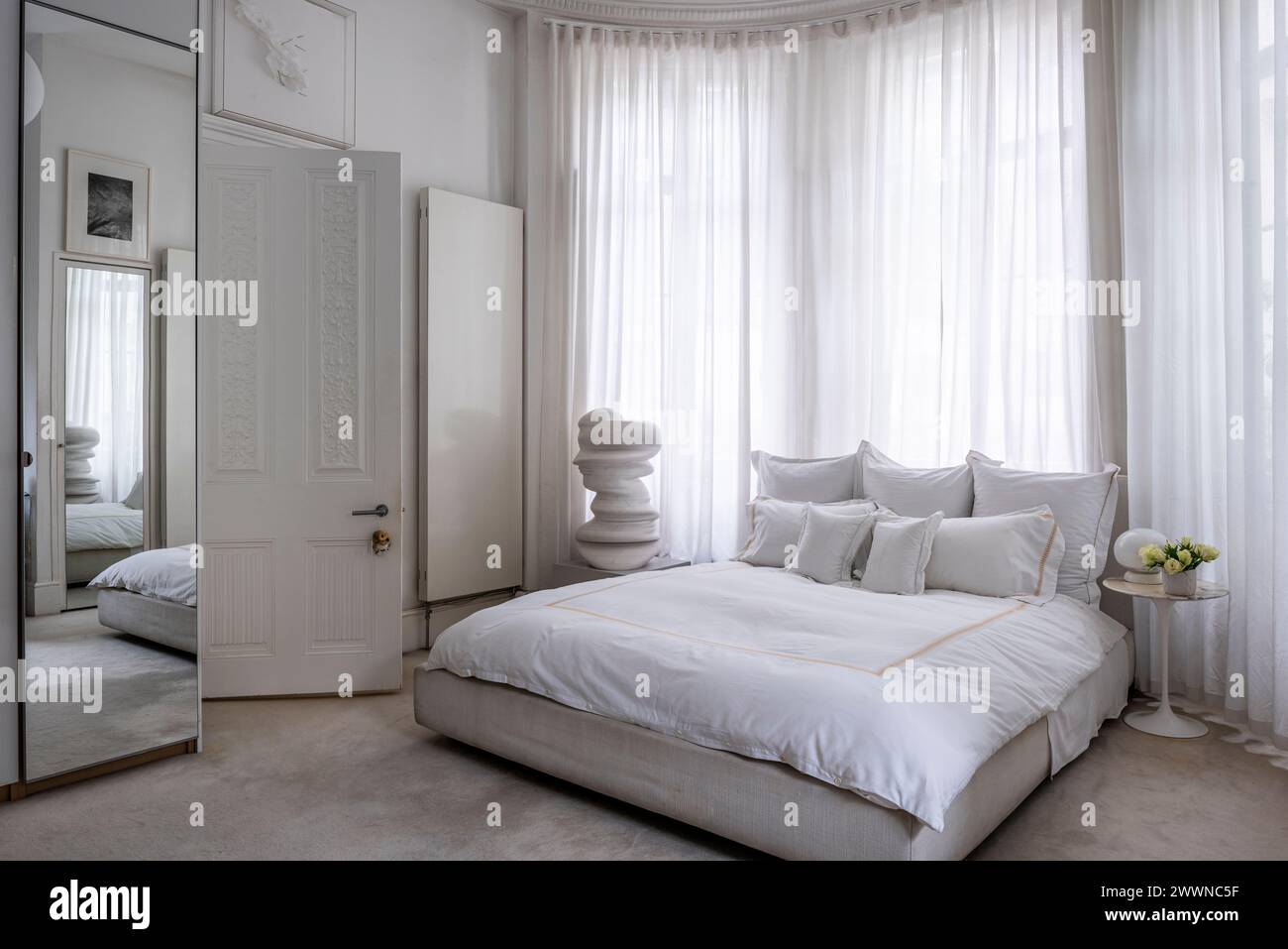 Camera da letto bianca con scultura d'arte moderna nell'appartamento West London, Regno Unito Foto Stock