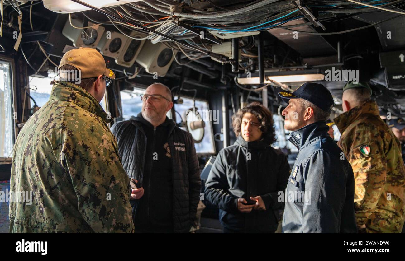 Sinistra, cmdr. Christopher W. Van Loenen, comandante della nave da sbarco classe Whidbey Island USS Gunston Hall (LSD 44), offre un tour del ponte ai giornalisti di un giornale locale Harstad, e l'italiano Rear Adm. Valentino Rinaldi, comandante, Amphibious Task Force per Steadfast Defender, durante un tour mediatico della nave a supporto di Steadfast Defender 24, 25 febbraio 2024, ad Harstad, Norvegia. Steadfast Defender 2024, il più grande esercizio della NATO da decenni, dimostrerà la capacità della NATO di dispiegare rapidamente forze da tutta l’Alleanza per rafforzare la difesa dell’Europa. Marina Foto Stock