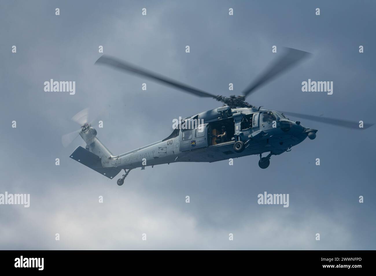 Un MH-60S Knighthawk della US Navy recupera i sopravvissuti simulati durante il Cope North 24 al largo della costa di Guam il 20 febbraio 2024. I partecipanti esercitano l'interoperabilità durante Cope North 24 attraverso una generazione agile e integrata di energia aerea da sedi dislocate nell'Indo-Pacifico, dimostrando la resilienza e la sopravvivenza dell'energia aerea alleata in un ambiente conteso. Aeronautica militare Foto Stock