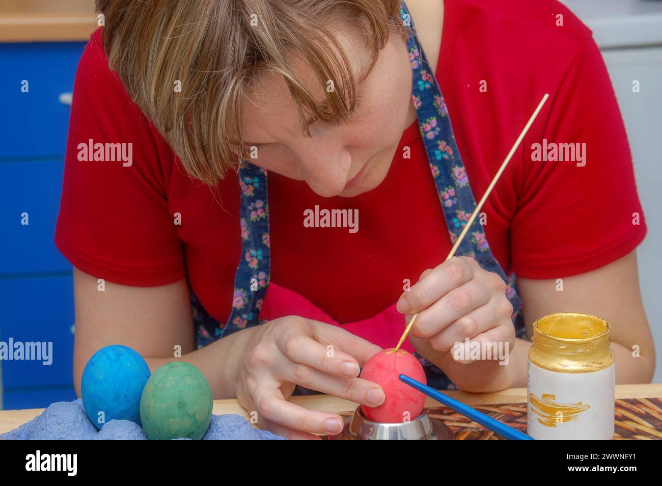 Giovane donna che pete uova di pasqua Foto Stock