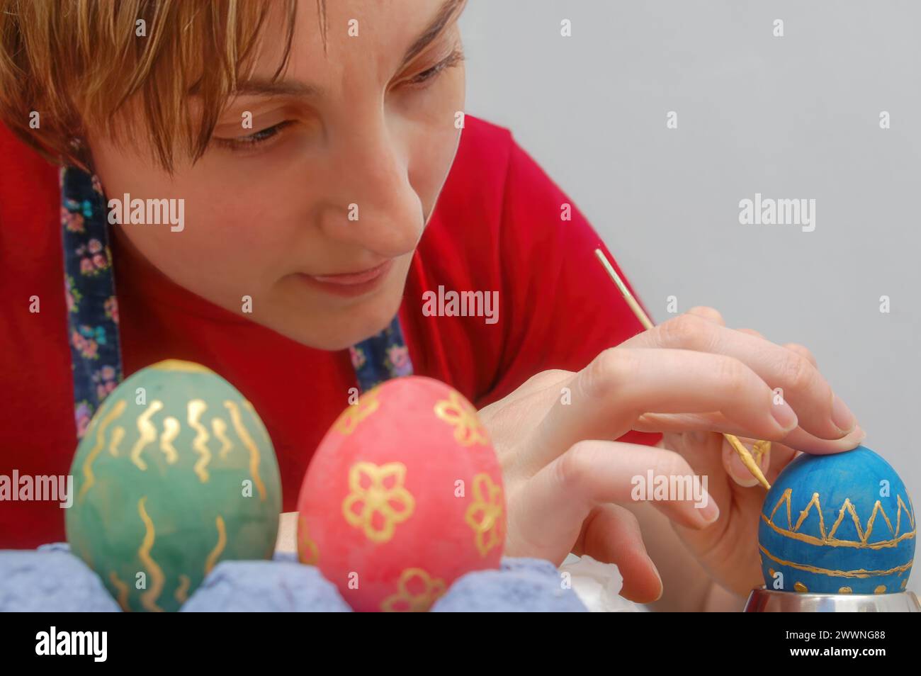 Giovane donna che pete uova di pasqua Foto Stock