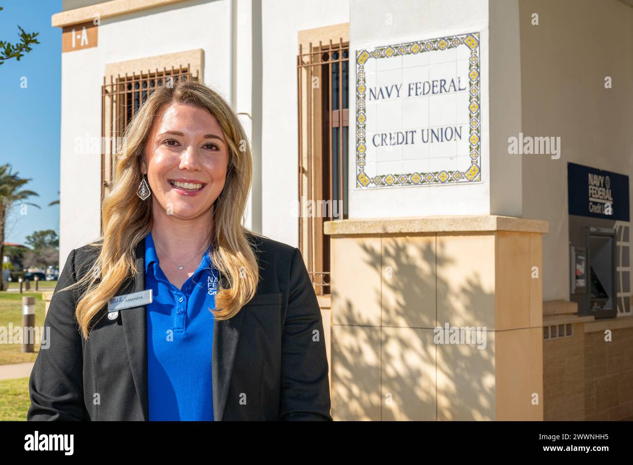 240228-N-NC885-2009 STAZIONE NAVALE di Rota, Spagna (28 febbraio 2024) Amanda Jones, l'assistente manager, succursale operazioni per la Navy Federal Credit Union (NFCU) Rota, Spagna, posa per una foto di fronte all'edificio NFCU, 28 febbraio 2024. NAVSTA Rota è un moltiplicatore di forze, in grado di dispiegare e sostenere prontamente forze pronte al combattimento attraverso terra, aria e mare, consentendo ai combattenti e alle loro famiglie, sostenendo la flotta e favorendo la partnership tra Stati Uniti e Spagna. Marina Foto Stock