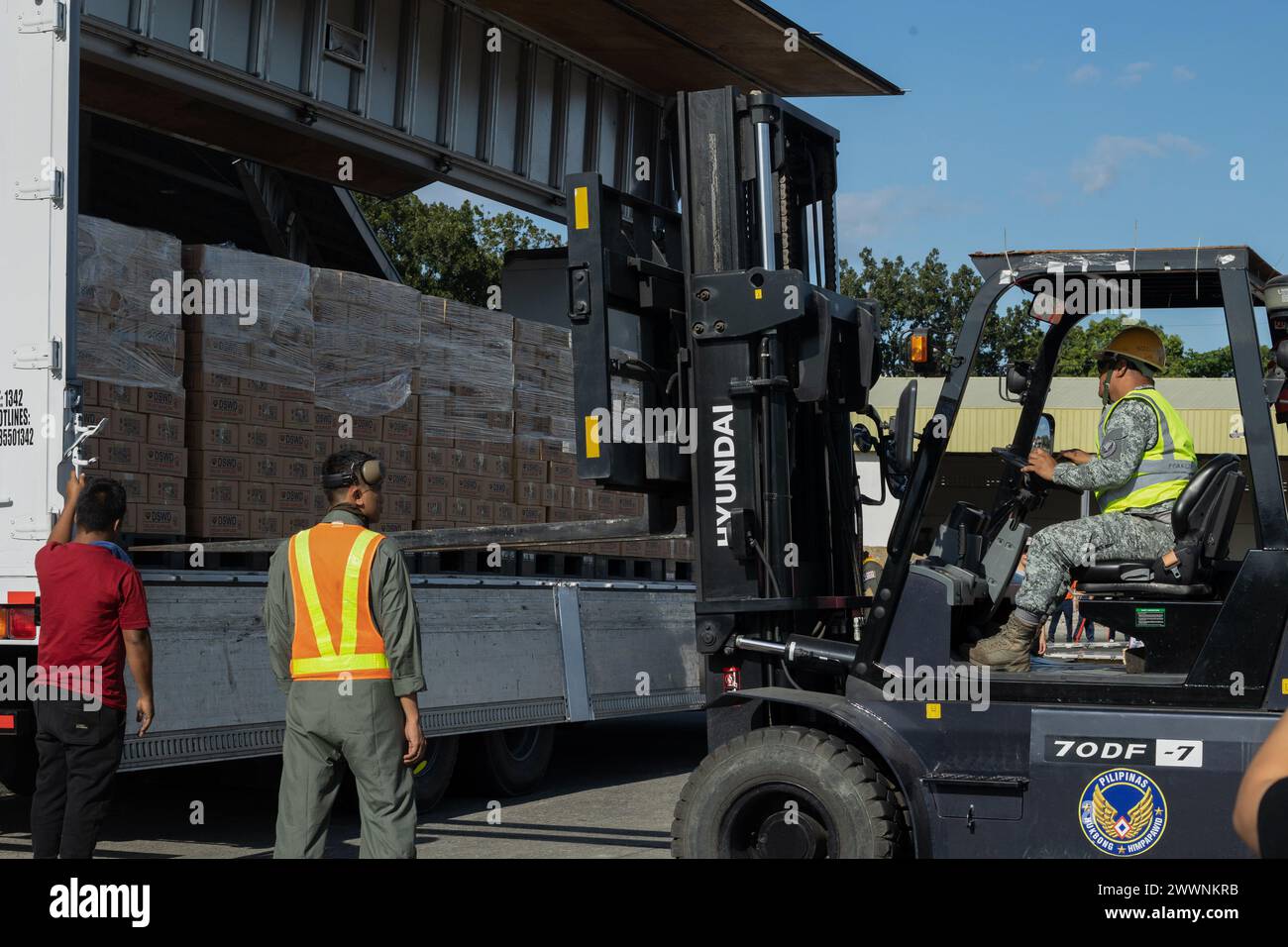 I membri del servizio dell'Aeronautica militare delle Filippine scaricano i pacchetti alimentari della famiglia Department of Social Welfare and Development da un camion in preparazione alla pallettizzazione per il trasporto alla base aerea di Villamor, Pasay City, Filippine, 11 febbraio 2024. Su richiesta del governo delle Filippine, i marines statunitensi della III Marine Expeditionary Force stanno sostenendo l'Agenzia statunitense per lo sviluppo internazionale nel fornire assistenza umanitaria straniera alla missione di soccorso in corso a Mindanao. La presenza a termine e la postura pronta degli attivi del MEF III nella regione hanno facilitato un re rapido ed efficace Foto Stock