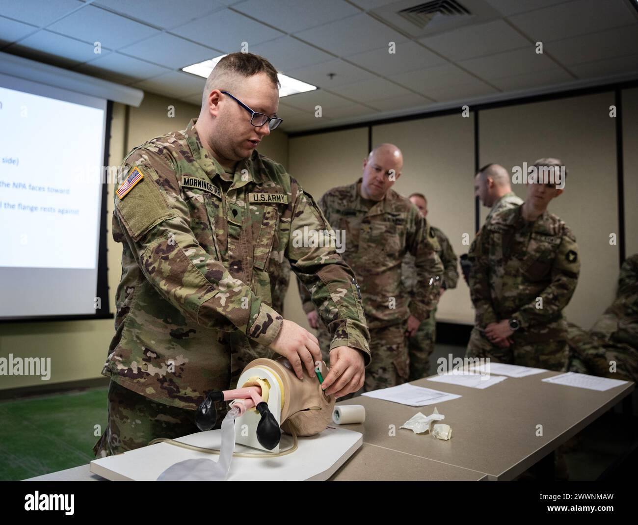 John Morningstar, un medico assegnato alla Headquarters Support Company, 34th Infantry Division 'Red Bulls', dimostra come inserire una via aerea nasofaringea utilizzando un addestratore medico per la gestione delle vie aeree durante una classe di cura della causalità di combattimento tattico per altri soldati Red Bull, Fort Cavazos, Texas, 10 febbraio 2024. I Red Bulls si stanno preparando per un dispiegamento in Medio Oriente alla fine di quest'anno. (Minnesota National Guard Foto Stock