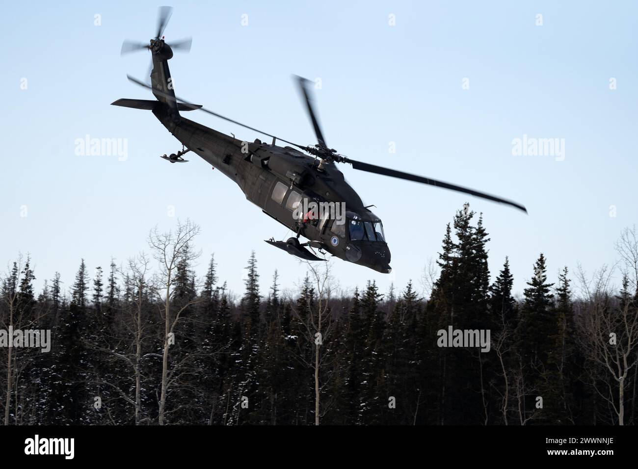 Un elicottero UH-60L Black Hawk della Guardia Nazionale dell'Alaska si avvicina ad una zona di atterraggio mentre supporta l'addestramento con carico di imbracatura alla Joint base Elmendorf-Richardson, 28 febbraio 2024. I soldati dell'esercito degli Stati Uniti dell'Alaska Army National Guard Aviation Battalion hanno condotto l'addestramento con le fionde per migliorare la loro capacità di operare nell'ambiente duro dell'Alaska. (Alaska National Guard Foto Stock