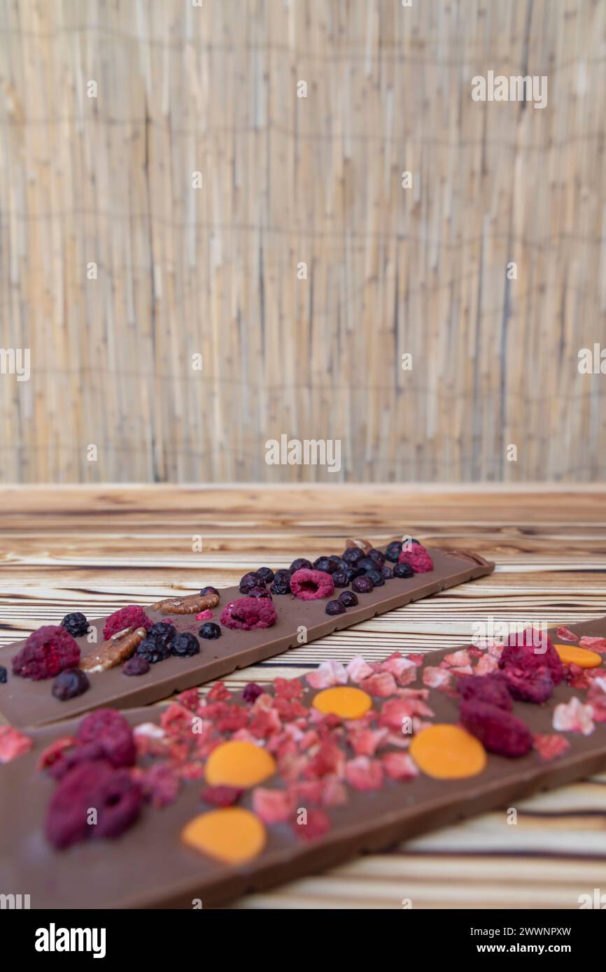 diversi tipi di cioccolato con frutta secca su tavola di legno Foto Stock