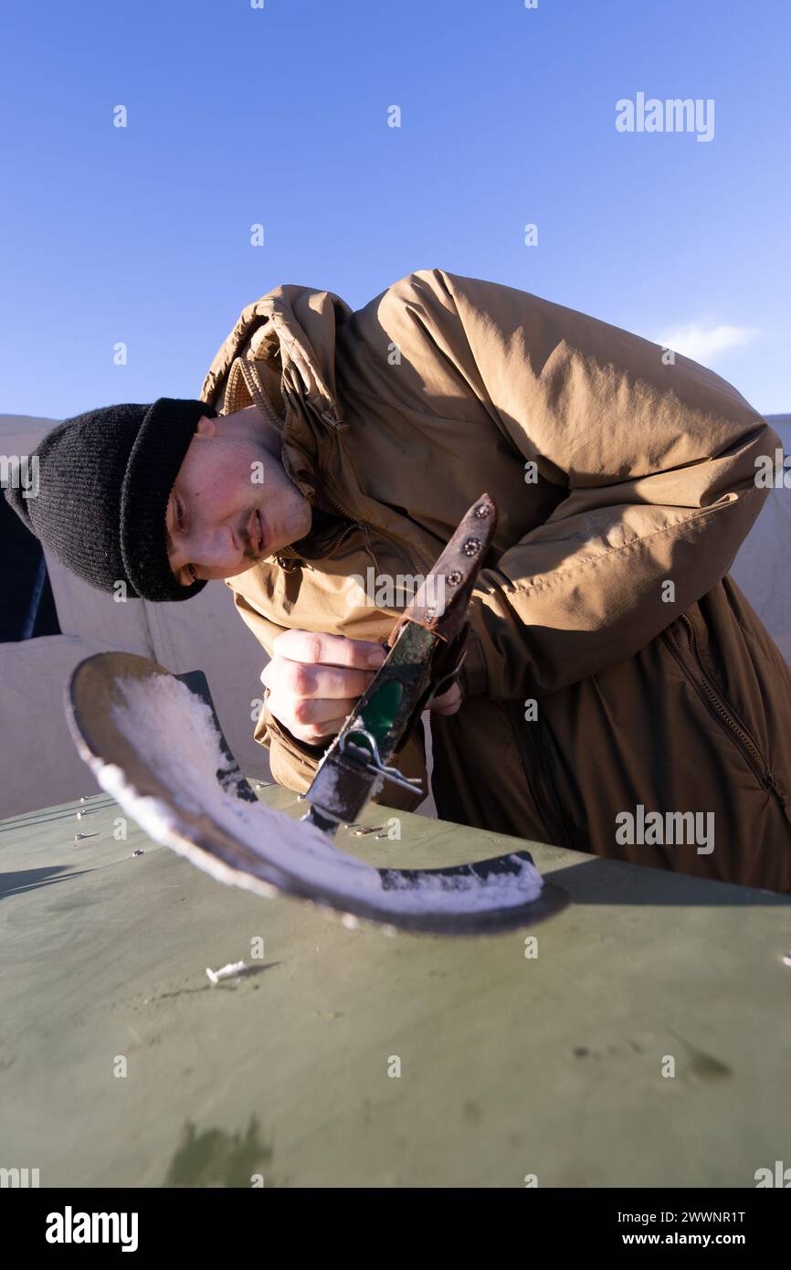 Joshua Schroeder, un tecnico dei sistemi di comunicazione dell'aviazione con Marine Air Control Squadron (MACS) 24, Marine Air Control Group 48, 4th Marine Aircraft Wing, Marine Forces Reserve, prepara uno strumento di trincea per eliminare la neve in eccesso a Fort Greely, Alaska, 10 febbraio 2024, in preparazione all'esercizio ARCTIC EDGE 2024 (AE24). AE24 è un'esercitazione di difesa interna guidata dal Northern Command degli Stati Uniti che dimostra le capacità dei militari statunitensi in condizioni di freddo estremo, la preparazione congiunta delle forze e l'impegno militare degli Stati Uniti per mutui interessi strategici di sicurezza nell'Artico regi Foto Stock
