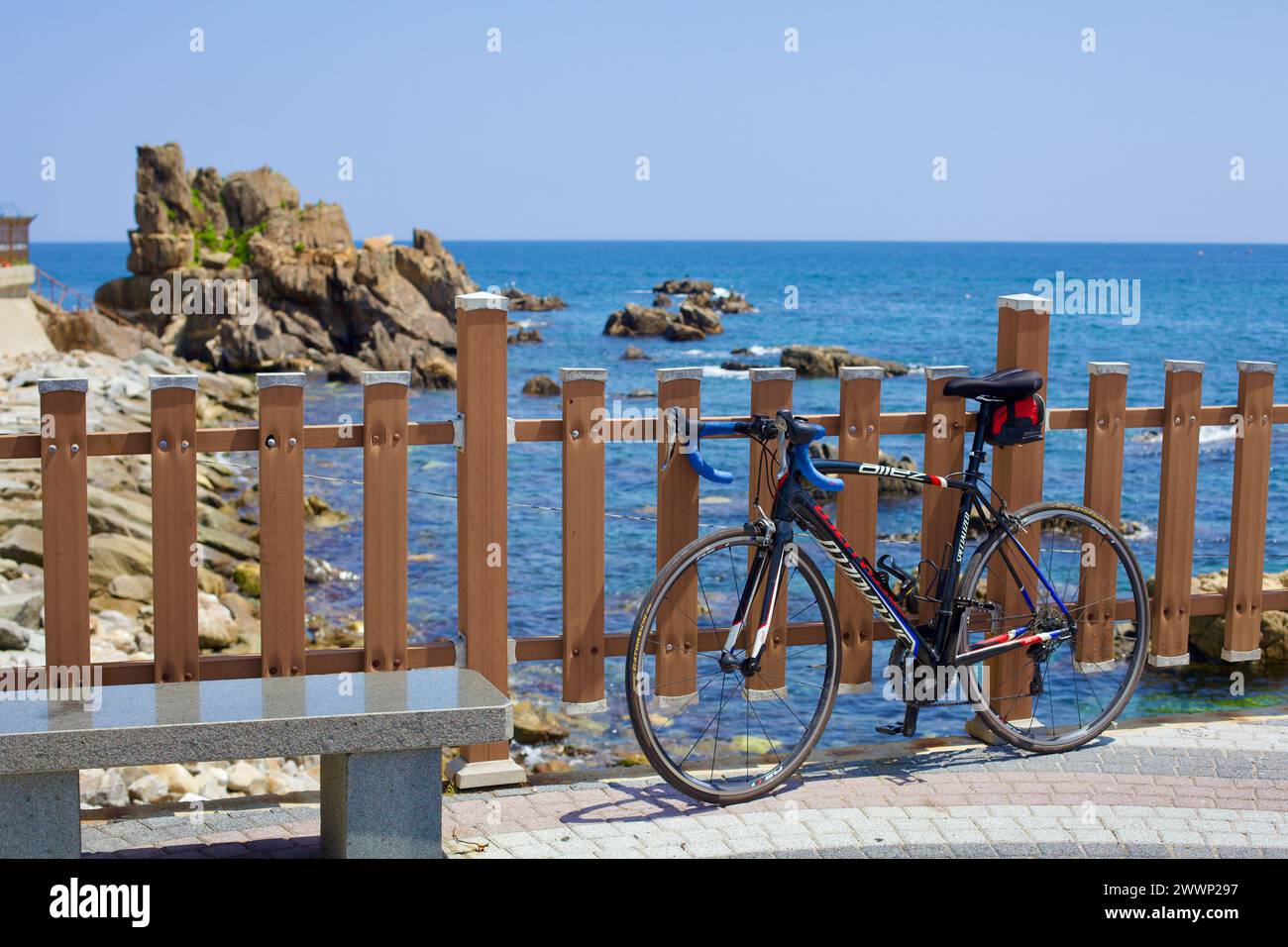 Contea di Goseong, Corea del Sud - 30 luglio 2019: Una bicicletta da strada si appoggia contro una recinzione su un patio panoramico vicino alla spiaggia di Geojin 1-ri e al porto di Geojin Foto Stock
