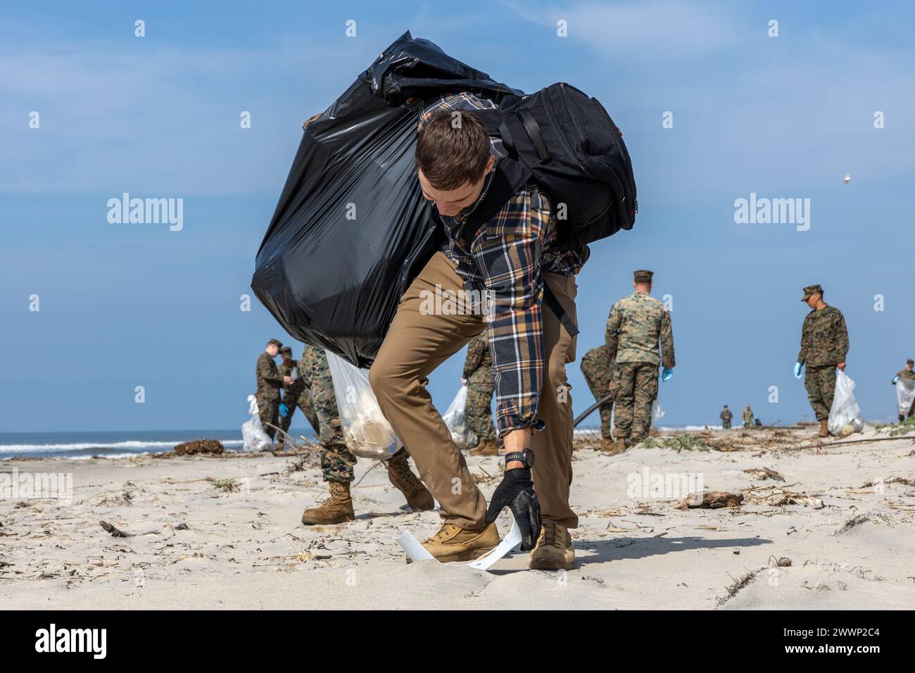 Chase Conrad, il capo dei rifiuti pericolosi del dipartimento di sicurezza ambientale di Camp Pendleton della base dei Marine, raccoglie un pezzo di spazzatura durante una pulizia della spiaggia a White Beach a MCB Camp Pendleton, California, 16 febbraio 2024. Questa pulizia consente a MCB Camp Pendleton e ai suoi locatari di condurre sforzi di conservazione armonizzando al contempo l'efficacia ambientale e la prontezza militare. MCB Camp Pendleton intraprende azioni attive per preservare la fauna selvatica regionale e le risorse naturali fornendo al contempo alla Fleet Marine Force gli spazi di addestramento necessari per soddisfare i requisiti di addestramento e preparazione. Ma Foto Stock