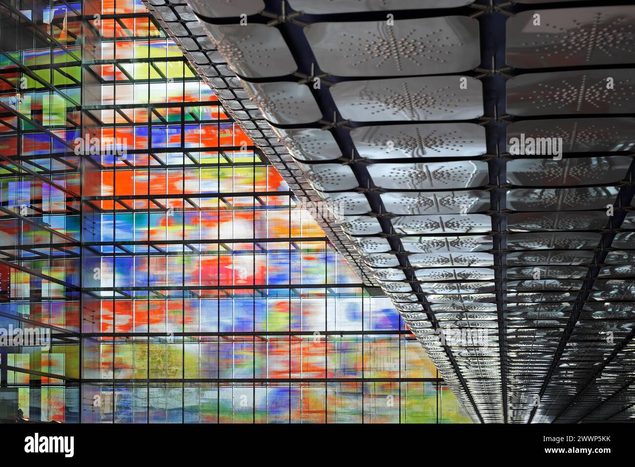 Parte inferiore delle lastre di alluminio nell'atrio, con facciata in vetro multicolore oltre. Dutch Institute for Sound & Vision, Hilversum, Paesi Bassi. Architetto Foto Stock