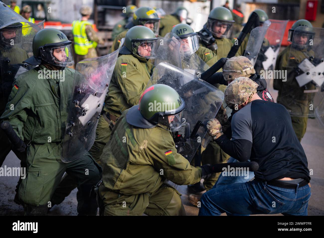 I soldati tedeschi respingono i rivoltosi simulati durante l'addestramento di controllo della folla durante le forze del Kosovo 33 (KFOR 33) esercitazione di prova della missione (MRE) nell'area di addestramento di Hohenfels, Germania, 10 febbraio 2024. KFOR 33 MRE è un evento di formazione multinazionale condotto per preparare il 48° IBCT (GA ARNG) e i partner multinazionali per il loro dispiegamento al comando regionale del Kosovo Est. Esercito Foto Stock