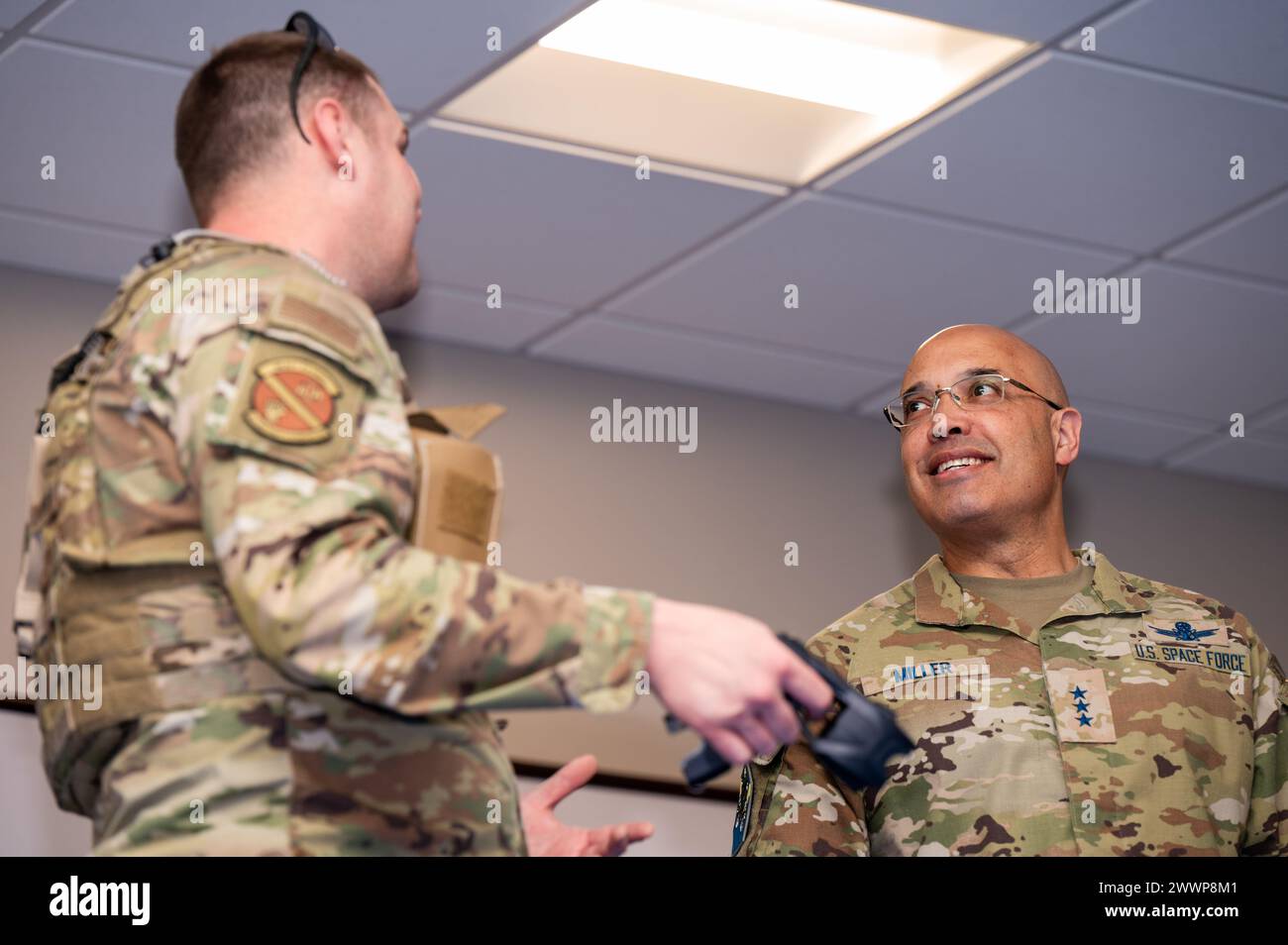 U.S. Air Force Tech. Il sergente Andrew Johnson, addestratore dell'unità 21st Security Forces, a sinistra, discute il protocollo taser con il tenente generale della US Space Force David N. Miller Jr. Alla Peterson Space Force base, Colorado, 29 febbraio 2024. Miller ha imparato a conoscere l'addestramento delle forze di sicurezza come parte del suo tour di immersione Delta 1 della base spaziale. Forza spaziale Foto Stock