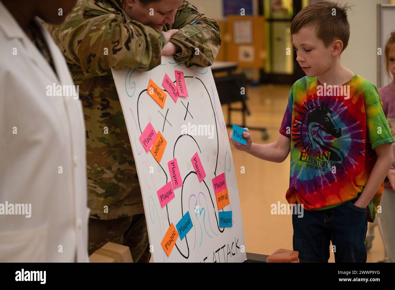 U.S. Air Force Senior Airman Terra Thomas, 51st Medical Group Dental Assistant, Left, e Capt. Theresa Ten-Haaf, General Dentist, middle, ospitano giochi a tema di igiene dentale per gli studenti della Osan Elementary School presso Osan Air base, Repubblica di Corea, 23 febbraio 2024. Gli aviatori assegnati alla clinica dentale 51st Medical Group hanno visitato la scuola per il mese nazionale della salute dentale dei bambini. Hanno condotto lezioni sulla salute dentale e hanno concluso la sessione con giochi interattivi e premi. Aeronautica militare Foto Stock