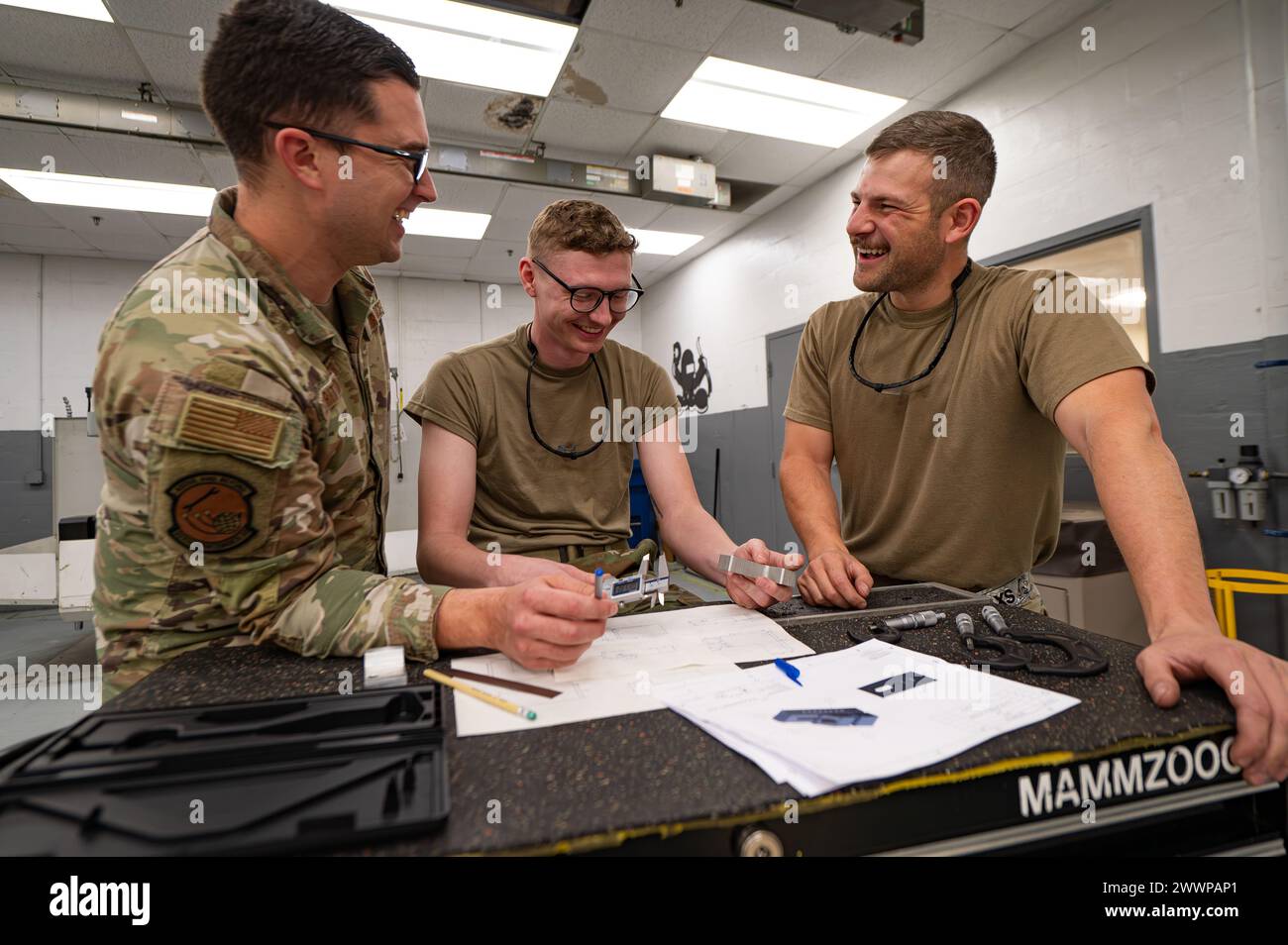 U.S. Air Force Technical Sgt. Ryan Strittmatter, 927th Air Refueling Wing Aircraft Metal Technician, Left, Airman Logan Ollis, 6th Maintenance Squadron Aircraft Metals apprendista, Center, and Airman 1st Class Thomas Allard, 6th Maintenance Squadron Aircraft Metals Technician, discutere i piani alla MacDill Air Force base, Florida., 21 febbraio 2024. Il 6° volo con tecnologia dei metalli MXS è fondamentale per le operazioni della base e, per estensione, per l'intera Air Force. Il loro lavoro incarna un mix di duro lavoro, dedizione, creatività e estrema precisione, elementi essenziali per eccellere in una foto Foto Stock