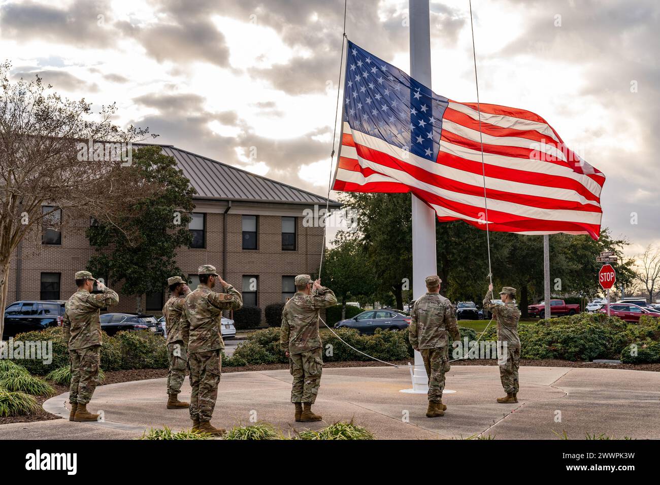 Gli U.S. Airmen presentano le armi mentre la bandiera degli Stati Uniti viene abbassata durante la cerimonia di ritiro dei guerrieri caduti alla Keesler Air Force base, Mississippi, 22 febbraio 2024. La cerimonia di ritiro si tenne per ricordare diversi guerrieri caduti. Aeronautica militare Foto Stock