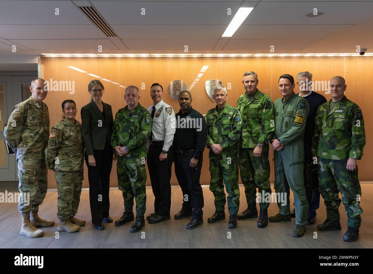 I delegati svedesi della difesa posano per una foto insieme alla dirigenza della Guardia Nazionale dell'aviazione e dell'esercito di New York e allo staff del Dipartimento di polizia di New York presso il Joint Operations Center del dipartimento a Manhattan, New York, il 9 febbraio 2024. La frequente interagenzia civile-militare della Guardia Nazionale di New York offre soluzioni uniche per operare in ambienti complessi e moderni come New York City. Guardia Nazionale dell'esercito Foto Stock