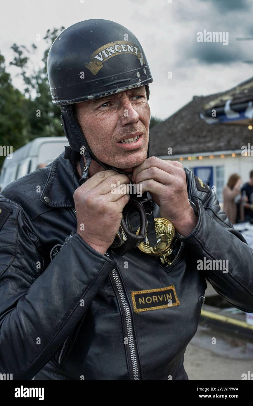 biker, caffè racer casco e occhiali di protezione sempre pronto. tondo su ragazzo casco di fissaggio. Foto Stock