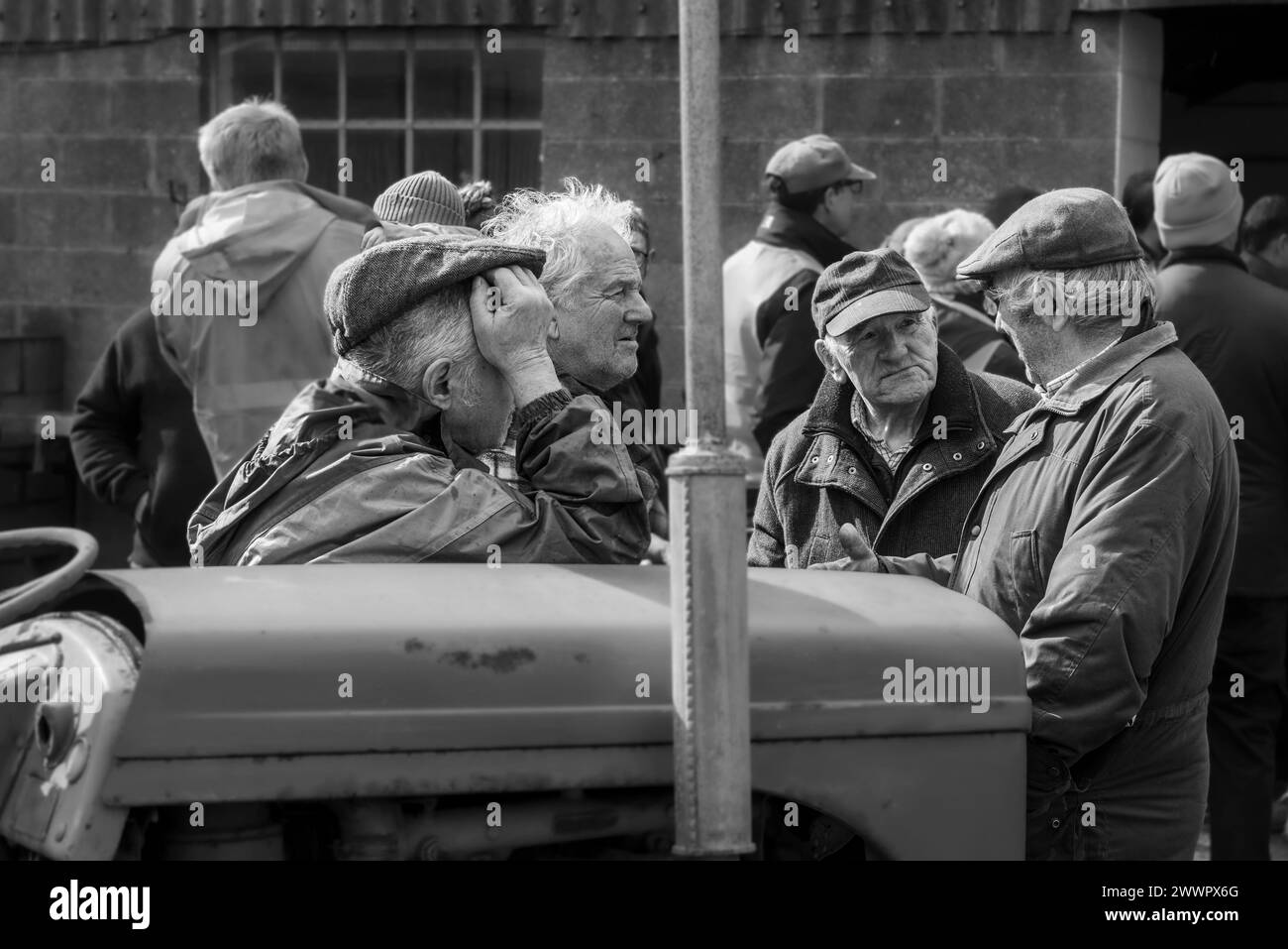 Un gruppo di agricoltori impegnati in una conversazione durante la vendita finale dei Taylor's Agricultural Engineers a Presteigne, Galles centrale, Regno Unito Foto Stock