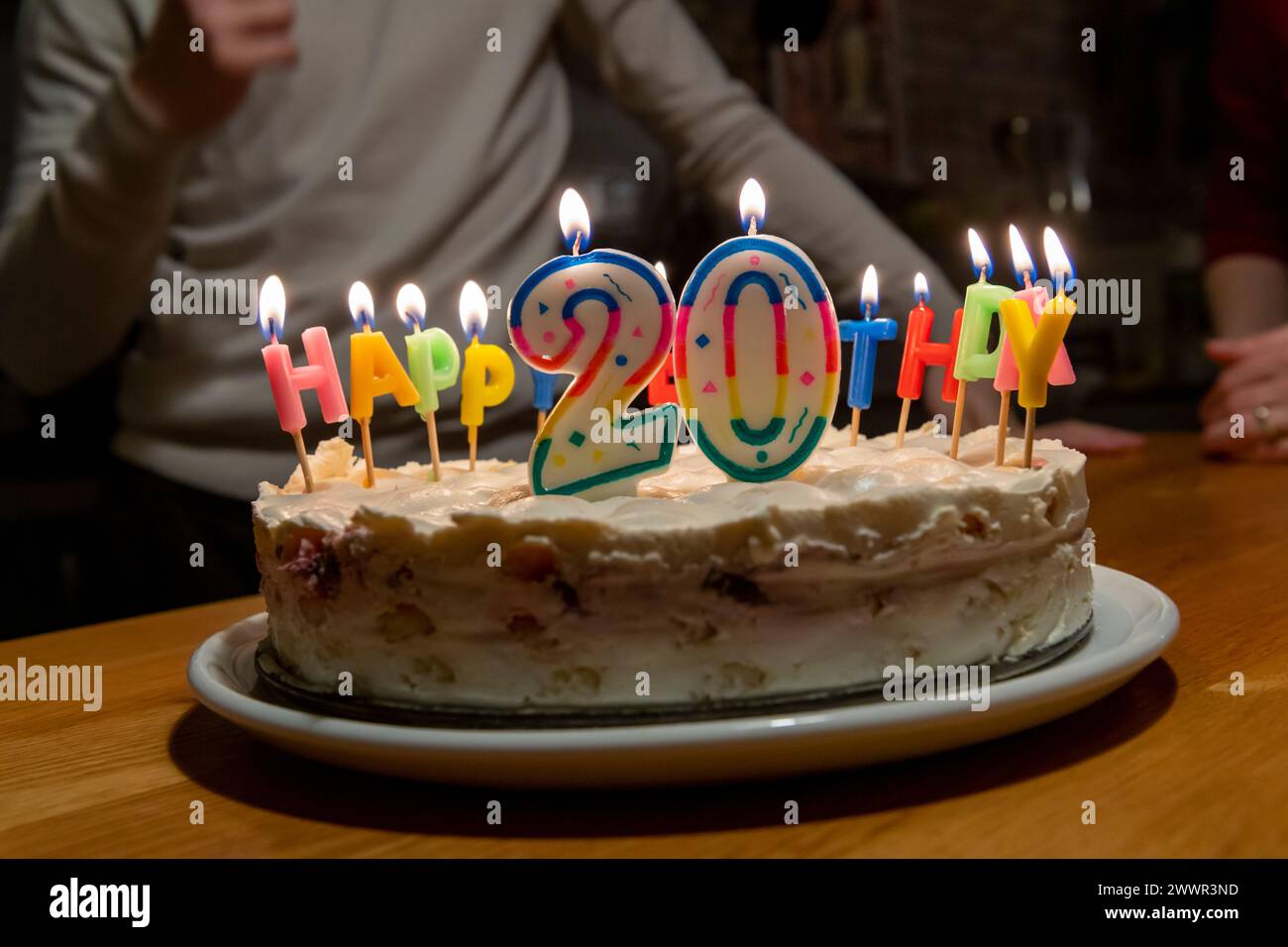 mani con fiammiferi che illuminano le candele vax sulla torta di compleanno Foto Stock