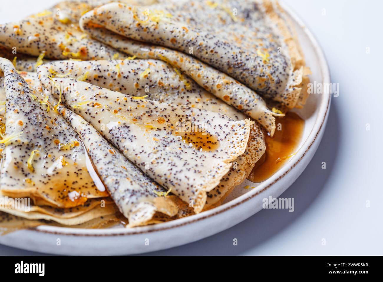 Crepes con semi di papavero, sciroppo d'acero e scorza. Ricetta russa dei pancake maslenitsa. Foto Stock