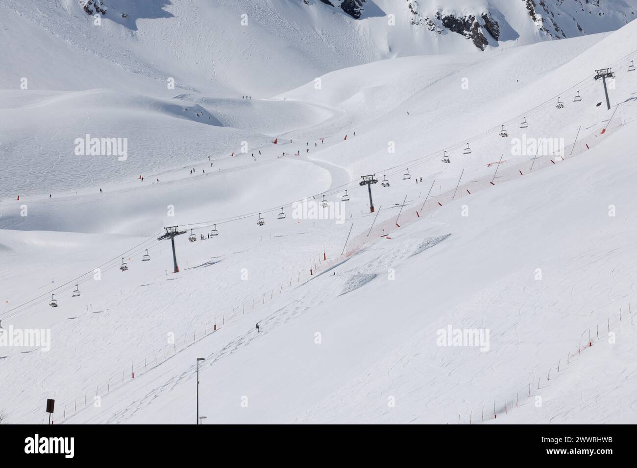 La seggiovia Tichot e la pista blu Carline ben curata alle sue spalle nel quartiere Val Claret di Tignes, una stazione sciistica ad alta quota delle Alpi francesi. Foto Stock