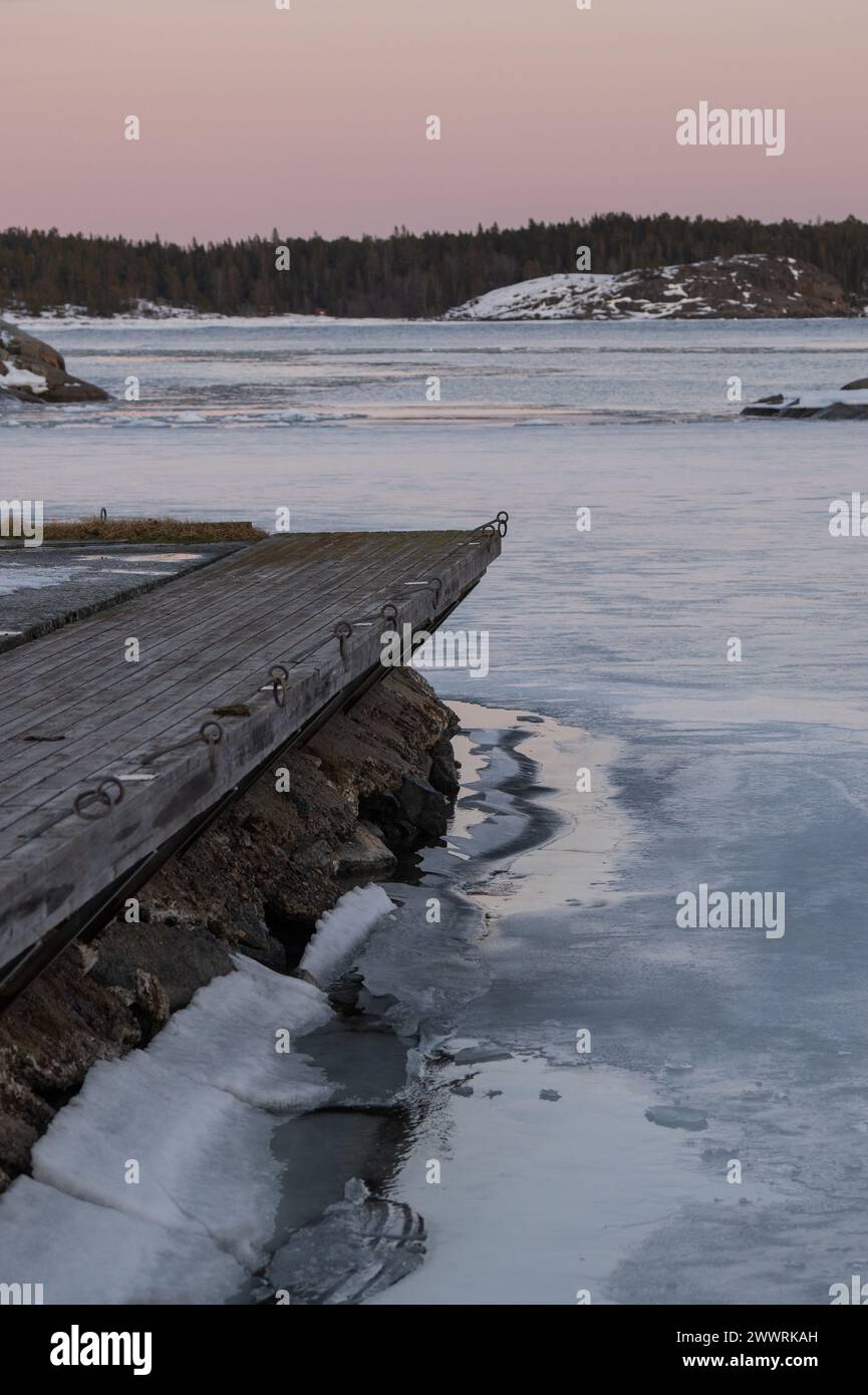 Una passerella di legno sopra un lago ghiacciato Foto Stock