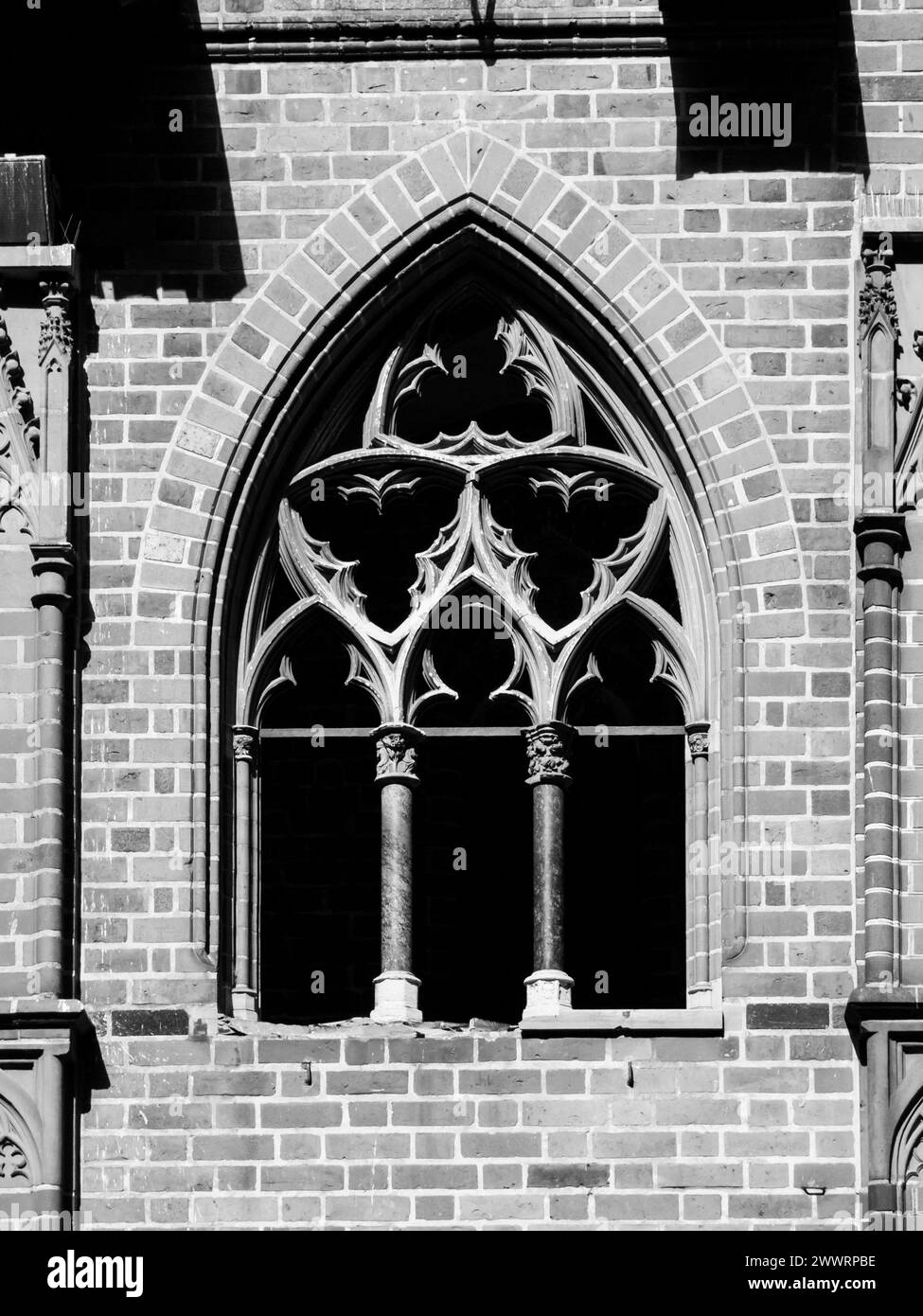 Finestra in mattoni d'epoca in stile architettonico gotico. Immagine in bianco e nero. Foto Stock