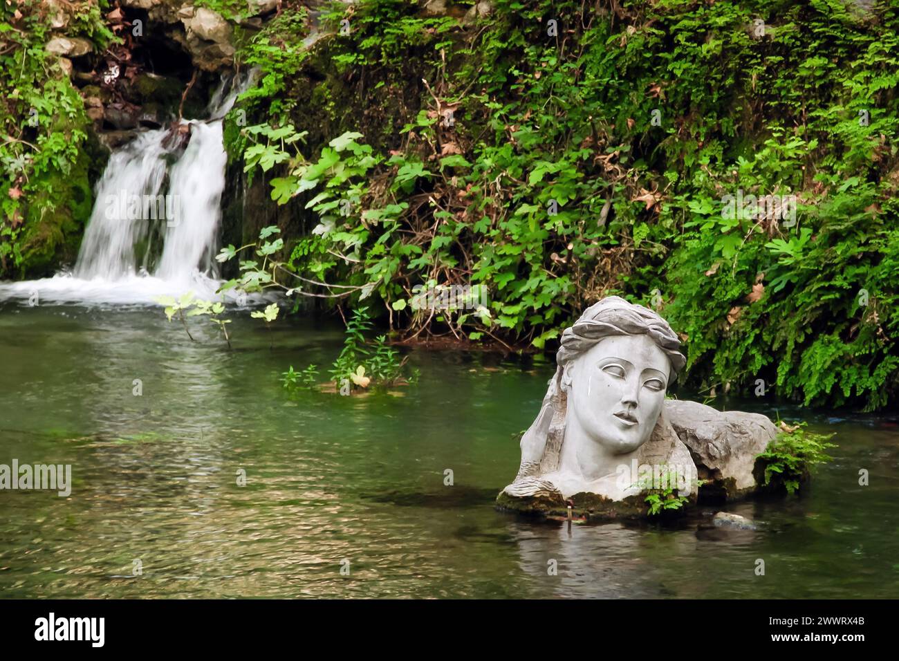 Fiume Erkyna, uno dei due fiumi di nome femminile in Grecia, nella città di Livadeia, Grecia centrale. Il busto della dea personifica Erkyna. Foto Stock
