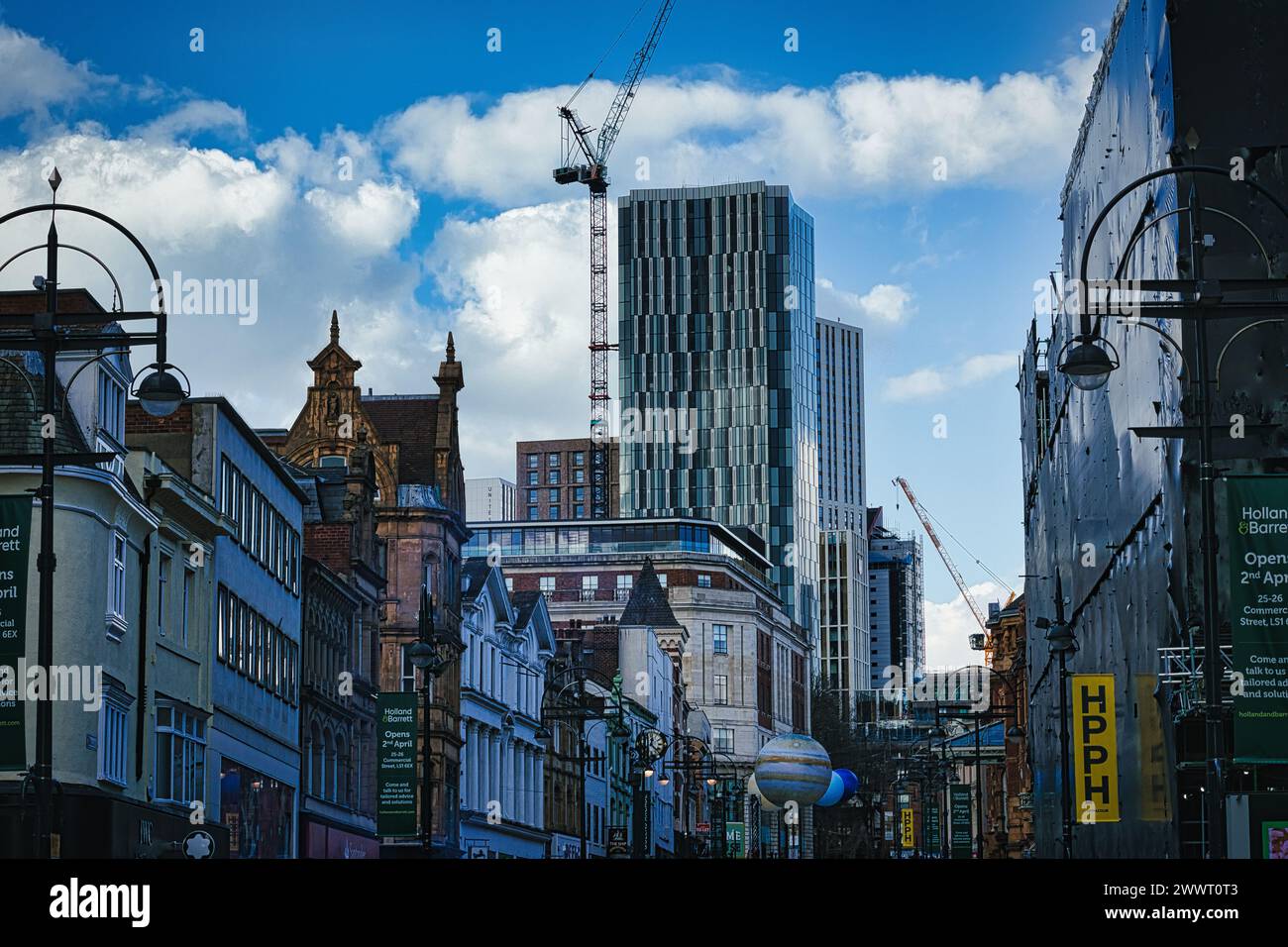 Paesaggio urbano con edifici storici e moderni grattacieli in costruzione contro un cielo blu con nuvole a Leeds, Regno Unito. Foto Stock