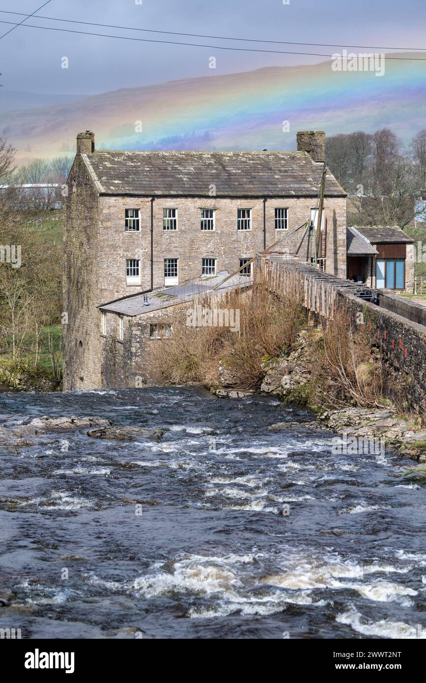 Arcobaleno sullo storico Gayle Mill, un mulino di cotone e lana del XVIII secolo sul Gayle Beck vicino ad Hawes a Wensleydale, nello Yorkshire Dales National Park. Foto Stock