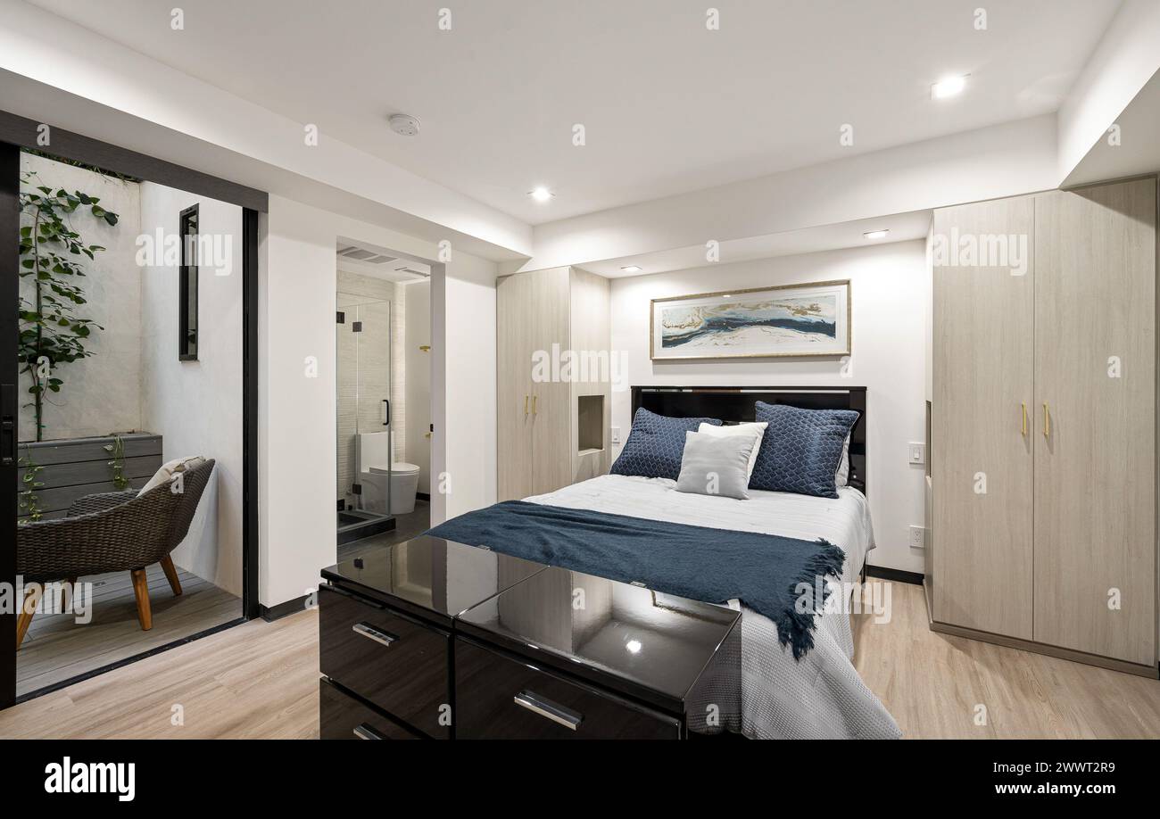 Camera dal design moderno con elegante biancheria da letto blu e bianca Foto Stock