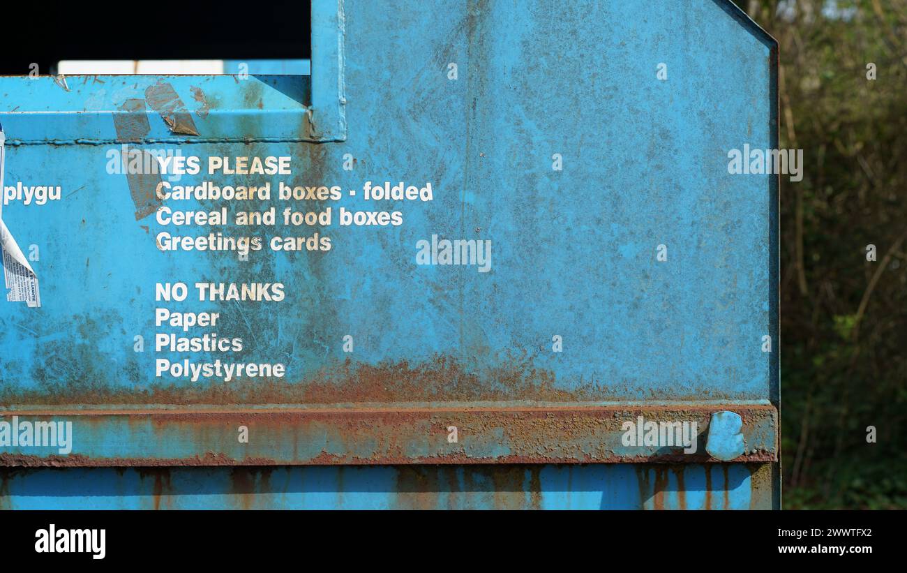 Un cassonetto blu con un cartello per accettare carta ma non plastica Foto Stock
