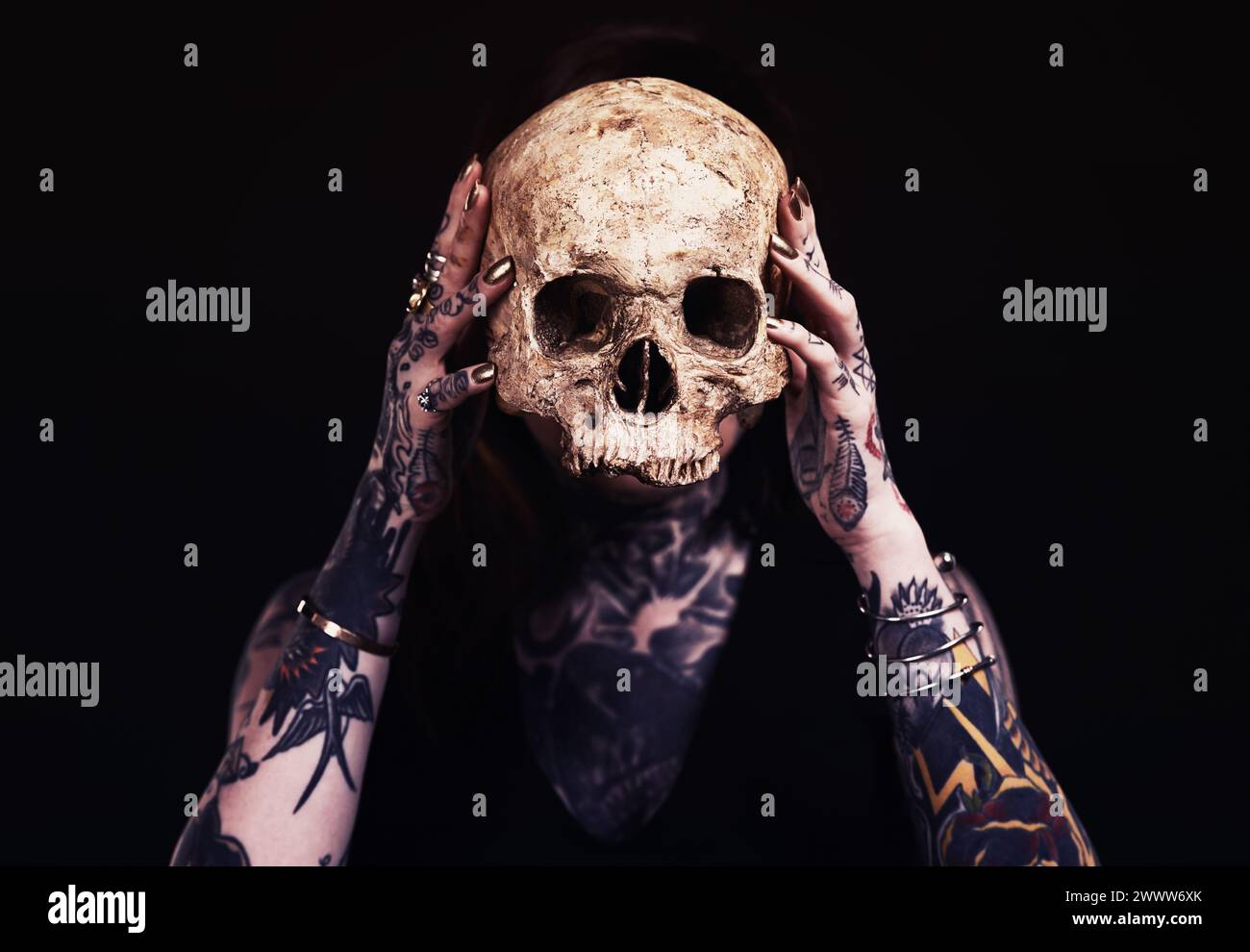 Teschio, arte e donna con tatuaggio in studio per magia oscura, orrore o estetica spaventosa con oggetto. Incubo creativo, cultura di halloween e unico Foto Stock
