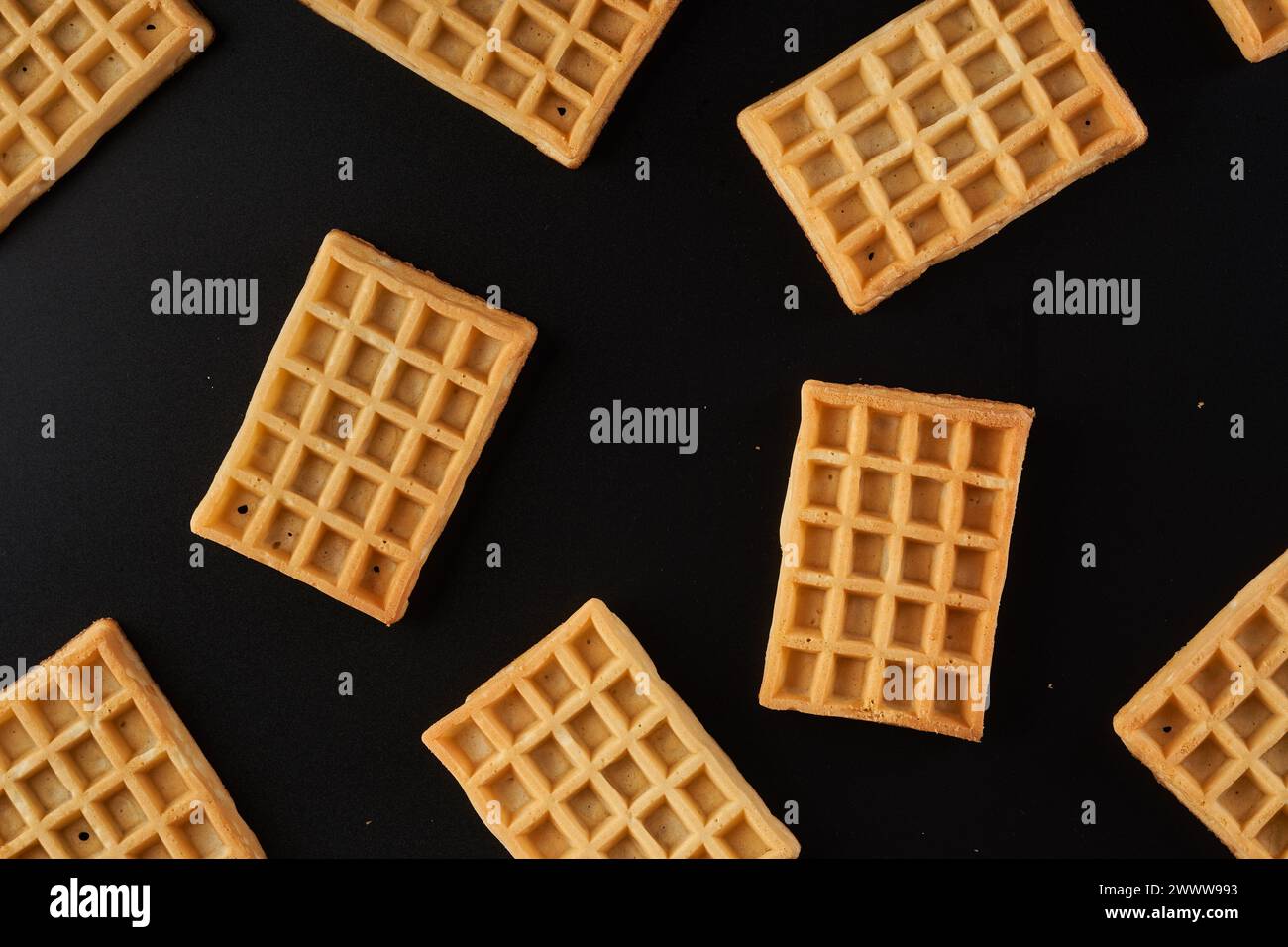 Molti waffle belgi in primo piano isolati su sfondo nero Foto Stock