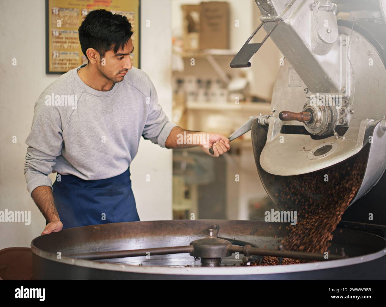 Chicchi di caffè, piccola impresa e uomo con macchina per tostatura con miscelazione, produzione e controllo qualità. Imprenditore, barista o torrefazione al bar Foto Stock