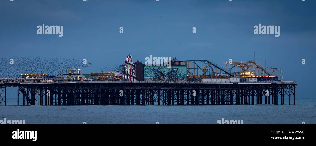 Brighton West Pier e Palace Pier durante un'alba rossa molto vivace sulla costa orientale del Sussex, Inghilterra sud-orientale, Regno Unito Foto Stock