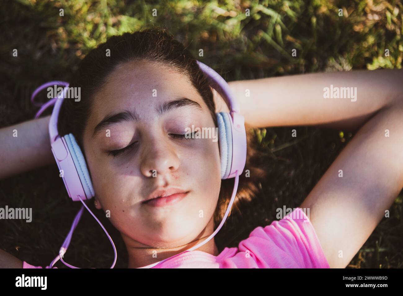 Una ragazza che ascolta musica con le cuffie, si diverte e si rilassa Foto Stock