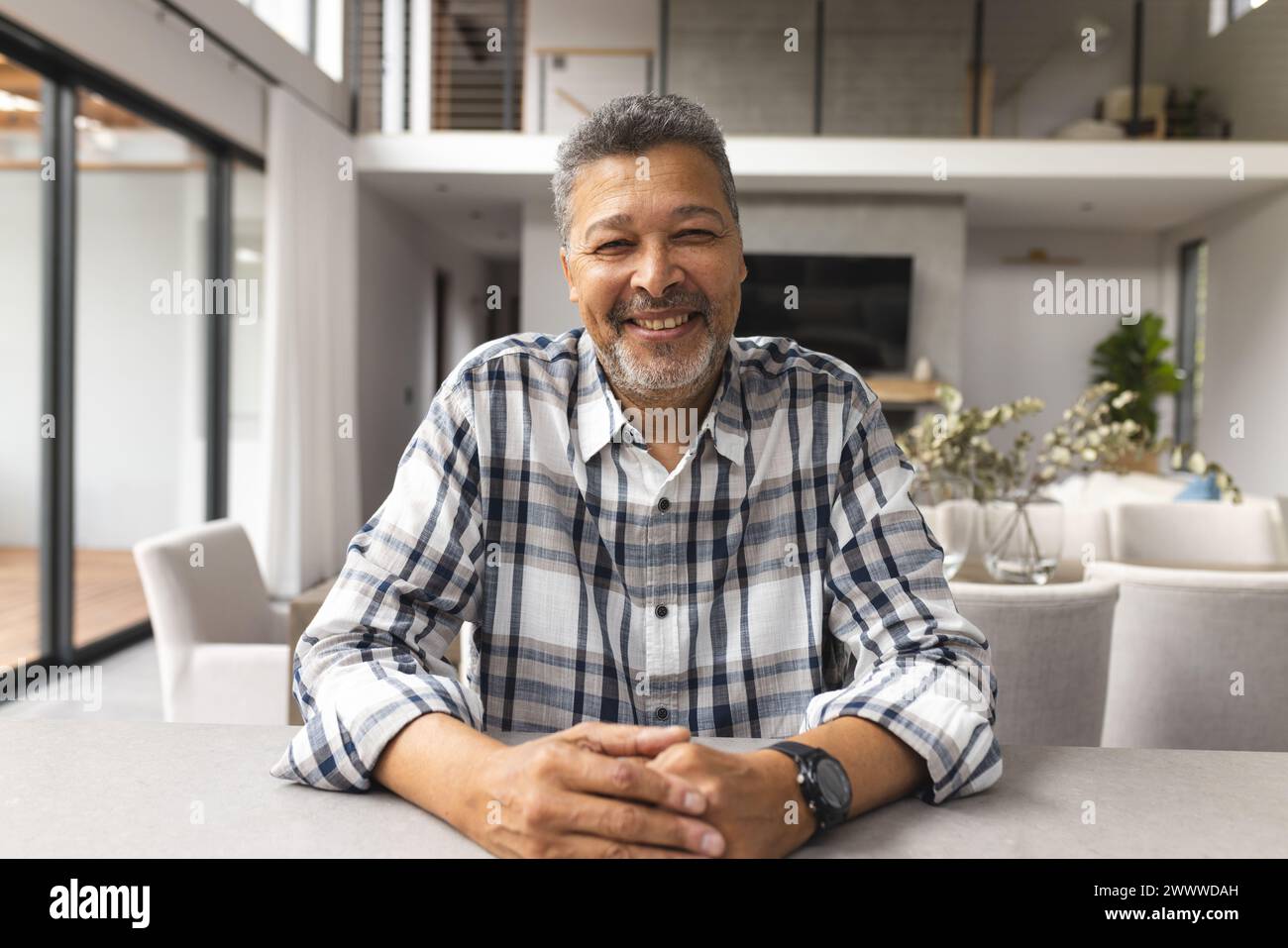 Un maschio birazziale anziano sorride alla telecamera in un video a casa Foto Stock