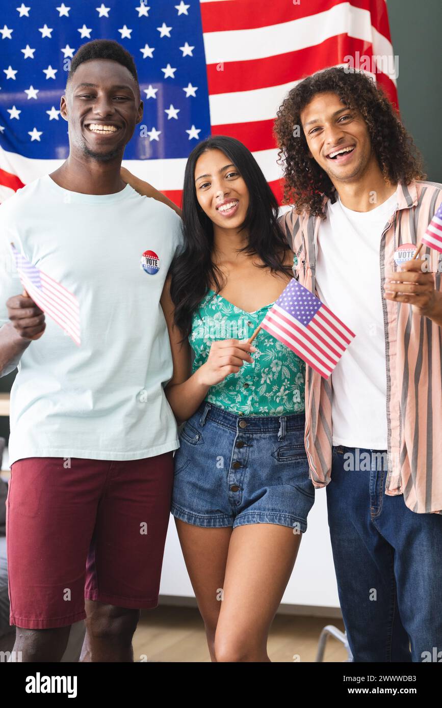 Un gruppo eterogeneo di amici si trova davanti a una bandiera americana Foto Stock