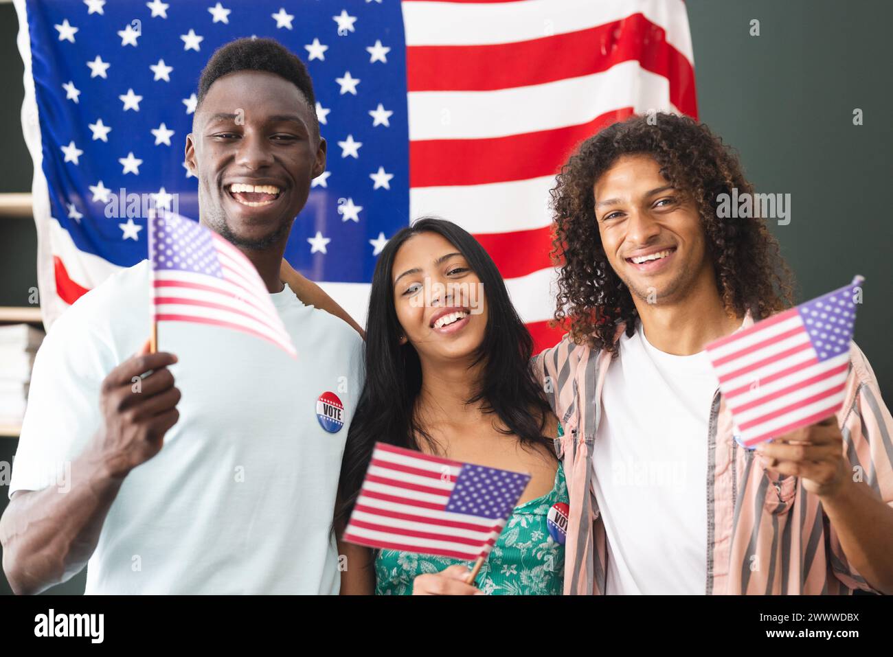 Un gruppo eterogeneo di amici festeggia con bandiere americane Foto Stock