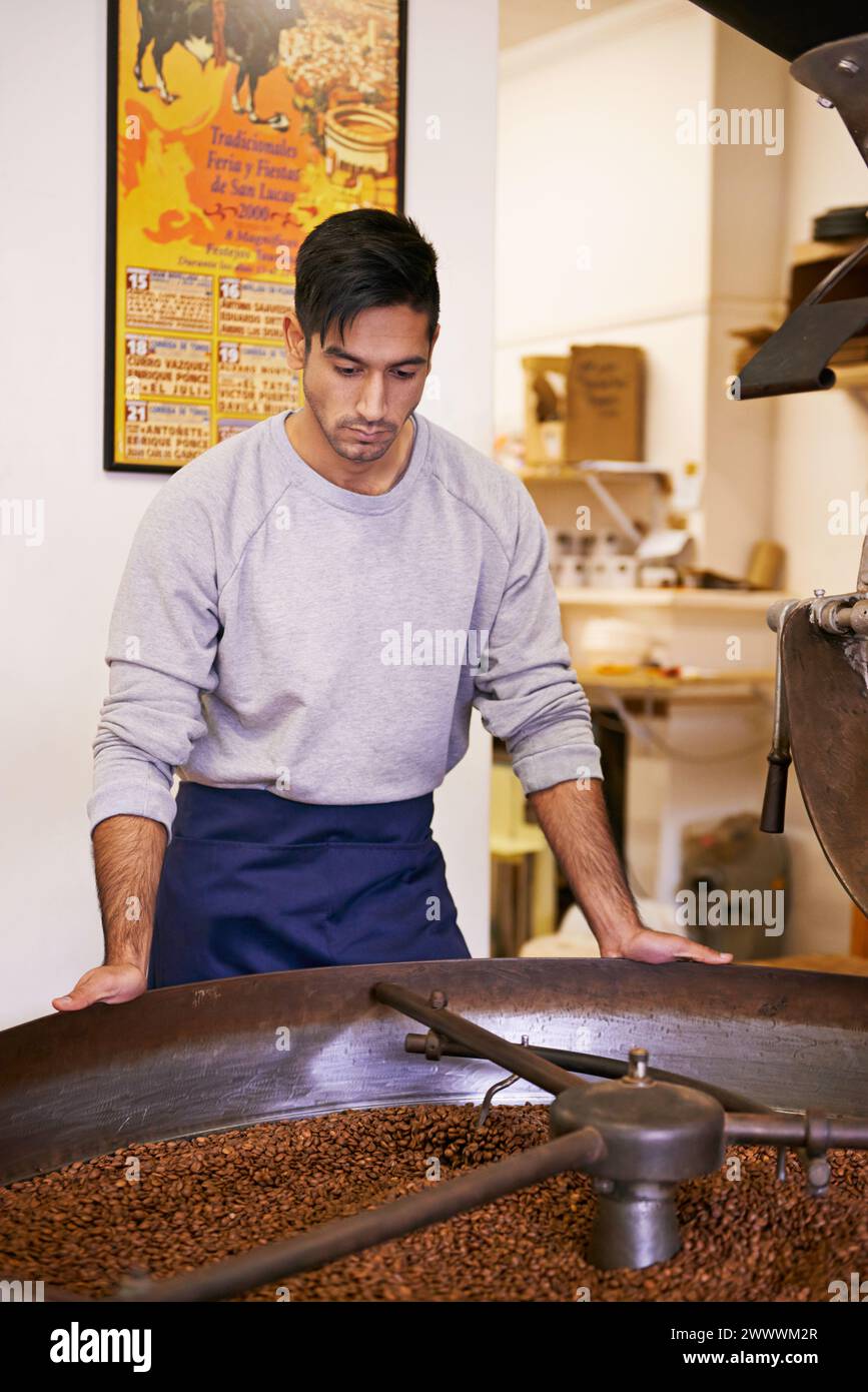 Caffè, qualità e uomo con macchina per tostatura, miscelazione, produzione e piccole imprese. Imprenditore, barista o tostapane con fagioli al bar Foto Stock