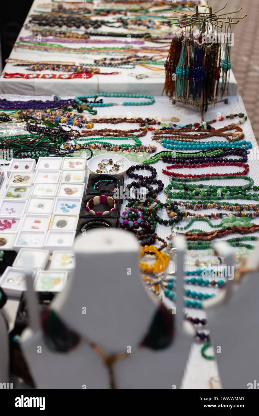 Varietà di collane e bracciali esposti su tavoli bianchi Foto Stock