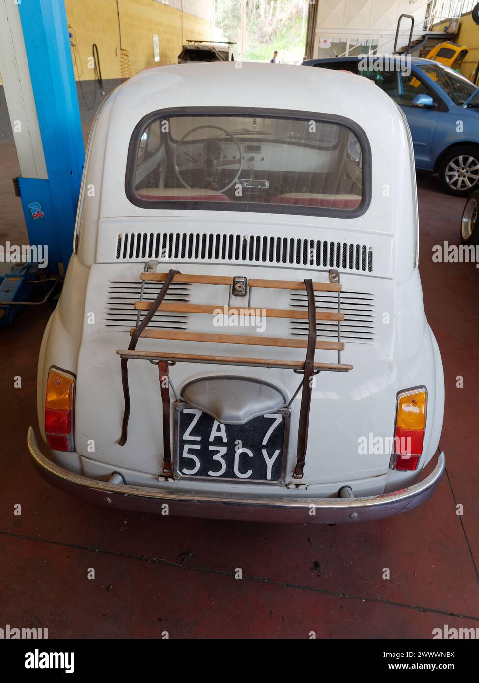 Retro di una Fiat 500 White Classic in un'officina meccanica che richiede interventi a Montefiascone, regione Lazio, Italia. 25 marzo 2024 Foto Stock