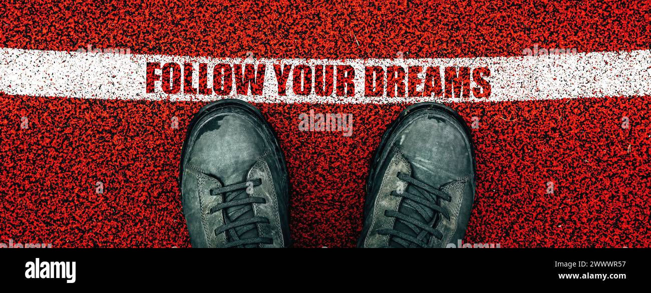 Segui il testo dei tuoi sogni sul pavimento in gomma del parco giochi, sugli stivali maschili dall'alto in piedi accanto alla linea, direttamente sopra Foto Stock
