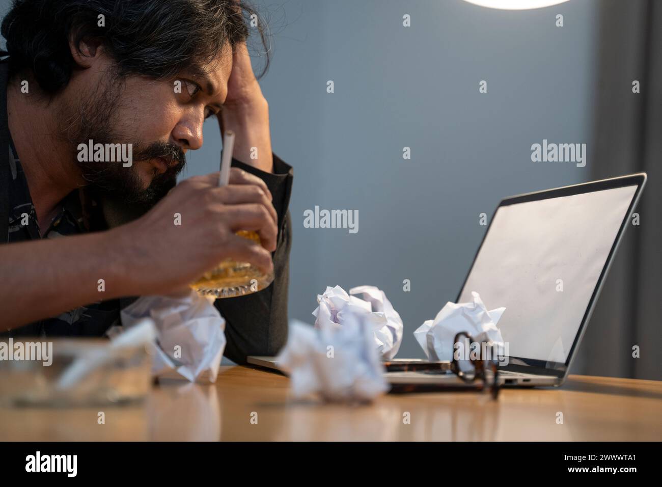 Giovane imprenditore maschio si sente esausto mentre lavora a casa. Foto Stock