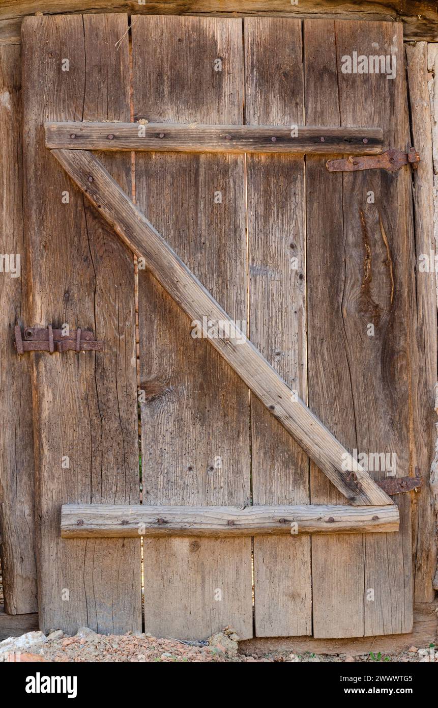 vecchia porta in tavole di legno, con cerniere e serrature in ferro, bellissime texture in legno Foto Stock