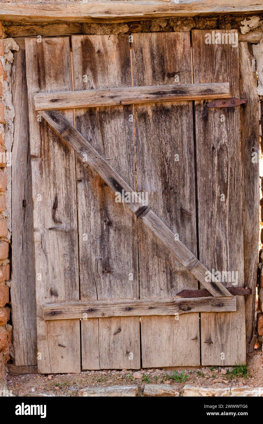 vecchia porta in tavole di legno, con cerniere e serrature in ferro, bellissime texture in legno Foto Stock