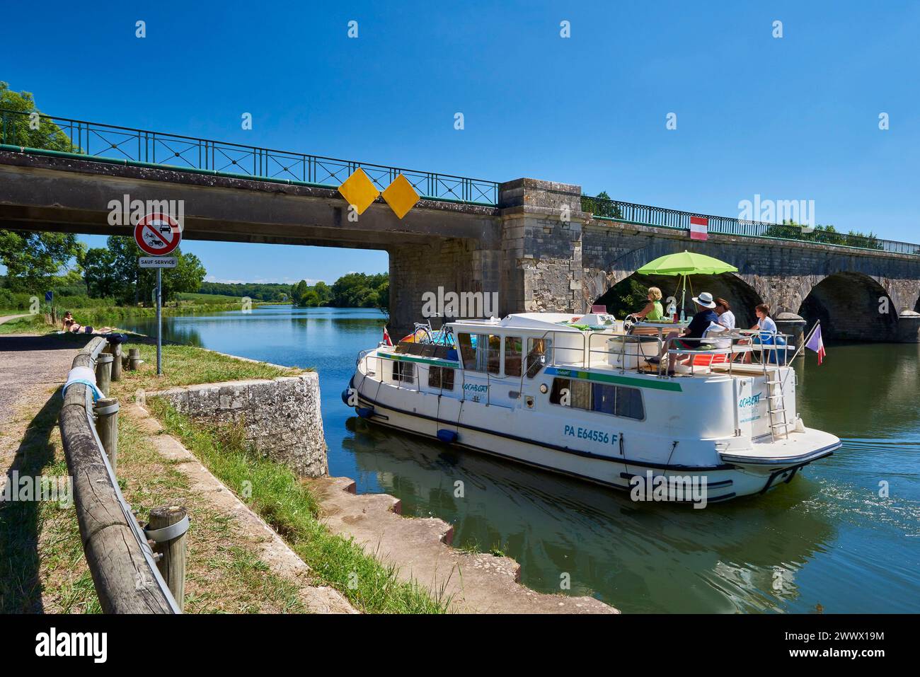 Navigazione sul canale navigabile Petite Saone a Rupt-sur-Saone (Francia nord-orientale): Chiatta locativa Locaboat Holidays che passa sotto un ponte Foto Stock