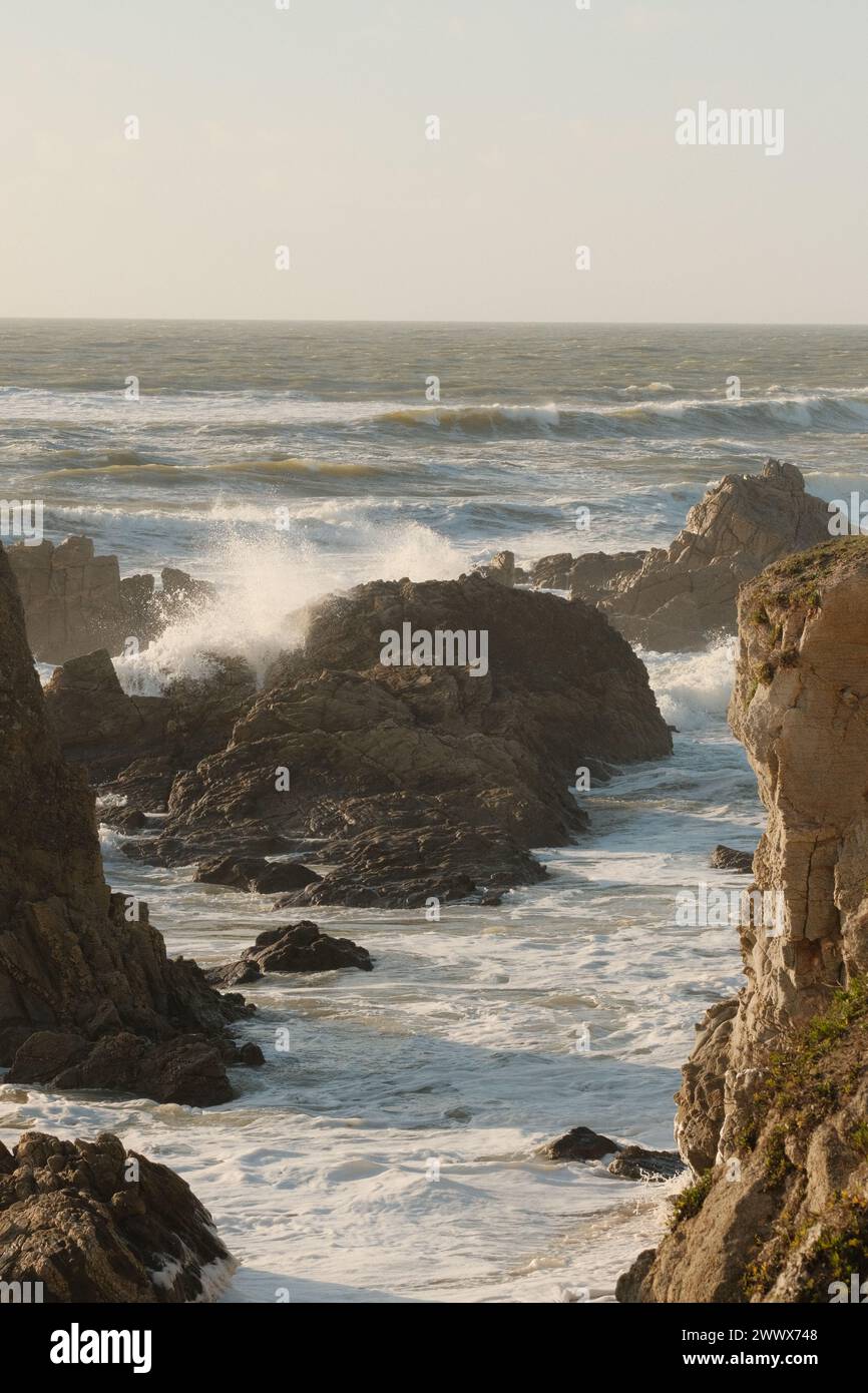 Le onde dell'oceano colpiscono le rocce lungo la costa Foto Stock