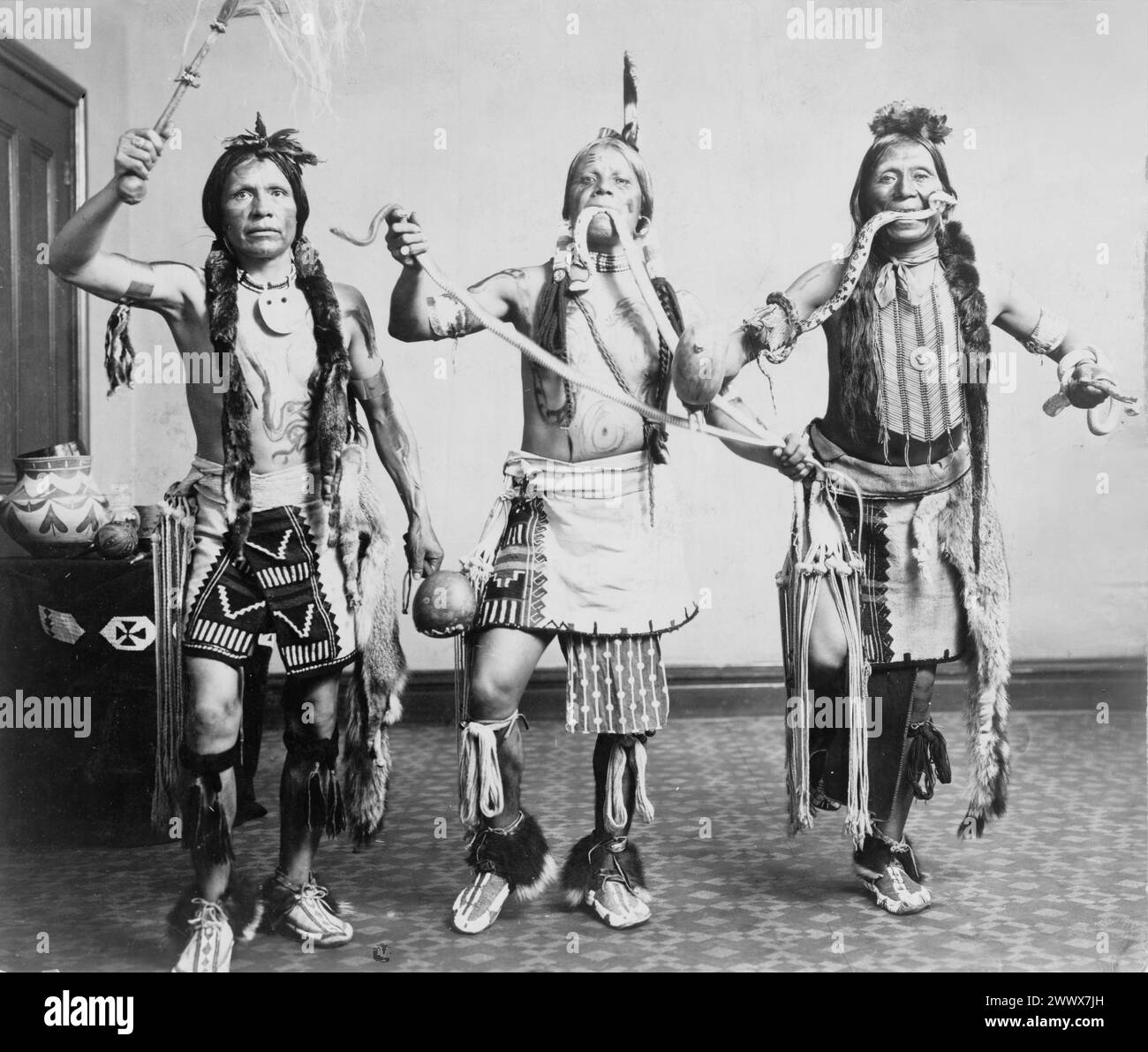 Gerhard Sisters - tre uomini nativi americani, in abiti tradizionali, si sono posi come se si esibissero in una danza serpente - 1905 Foto Stock